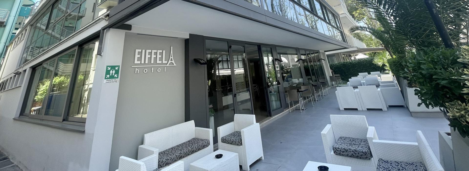 Hotel moderno con terrazza, arredamento bianco e palme.